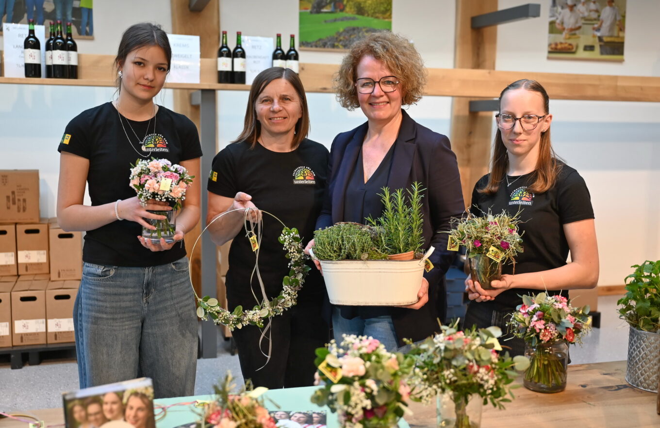 Schülerin Lea Biberosch, Fachlehrerin Barbara Hobiger, Bildungs-Landesrätin Christiane Teschl-Hofmeister und Schülerin Sonja Hoppel präsentieren selbst gestaltete Türkränze und Kräutertöpfe